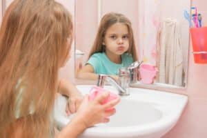 child rinsing tooth