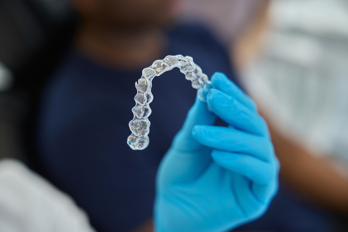 Dental aesthetic clinic worker holding clear aligners to straight teeth Dental aesthetic clinic worker holding clear aligners to straight teeth